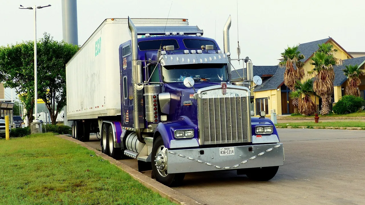 A semi truck parked at the side of a road.