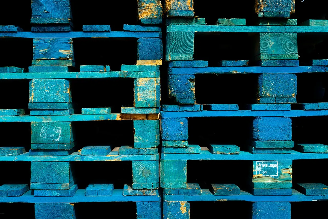 Close-up of stacked wooden pallets with barcodes in a warehouse environment.