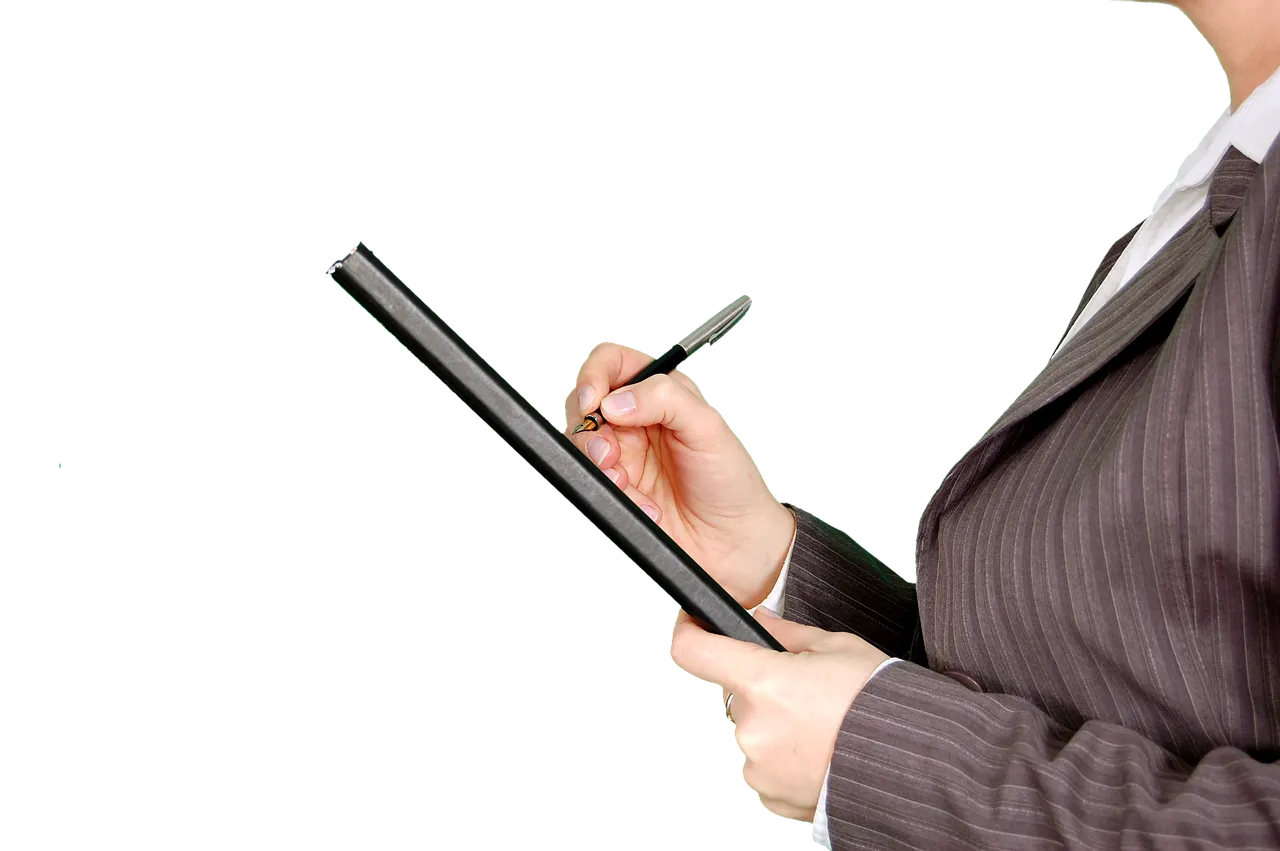 Professional in a suit writing on a tablet with a stylus.